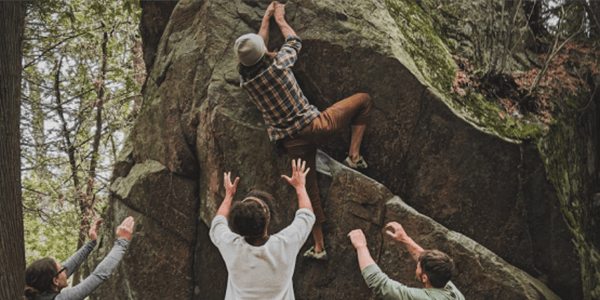 ロッククライミングの男性を三人でフォローしている画像